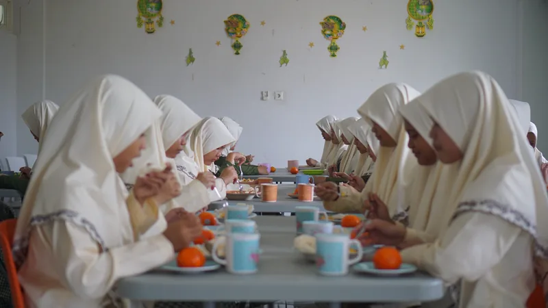 Santri putri menikmati waktu makan bersama di ruang makan
